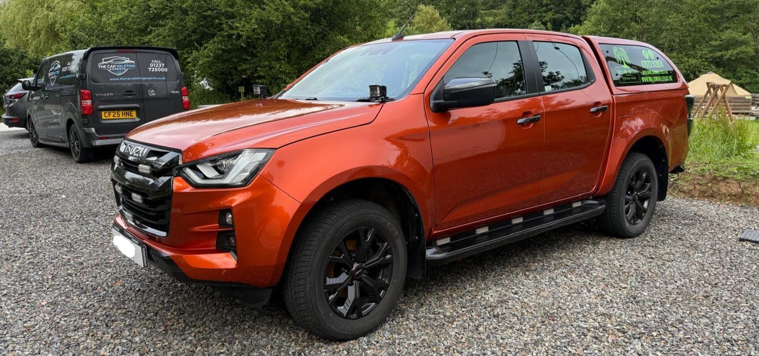 Orange Isuzu pickup after an exterior valet